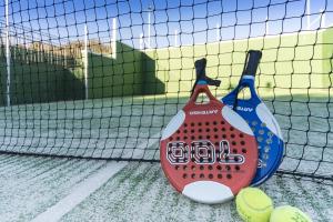 two baseball equipment sitting on a tennis court at Exe Zarzuela Park in Madrid