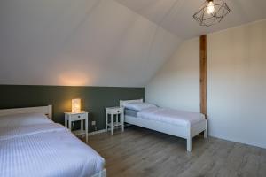 two beds in a room with green walls and wooden floors at Agroturystyka Milówka in Jagodzin