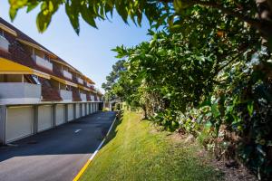 an empty street next to a building with trees at Motel Bracancún in Aveleira