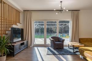 a living room with a tv and a couch and a chair at Agroturystyka Milówka in Jagodzin