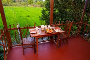 a wooden table with a bowl of food on a porch at Comfort Treehouse Pidurangala in Dambulla