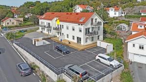 a large white house with cars parked in a parking lot at Luxurious apartment in central Grebbestad! in Grebbestad