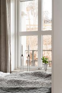 a bedroom with a window and two candles on a bed at Luxurious apartment in central Grebbestad! in Grebbestad