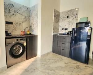a kitchen with a refrigerator and a washing machine at La Vida Colva Beach Resort in Colva
