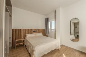 a white bedroom with a bed and a mirror at Aparthotel L' Alcor in Alicante +38 photos