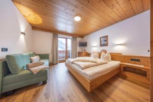 a bedroom with a large bed and a chair at Ausserwieserhof in Neustift im Stubaital