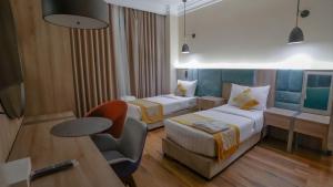 a hotel room with two beds and a chair at فندق رؤيا الاندلس النخبة - Roaya Alandalus Elite Hotel in Medina