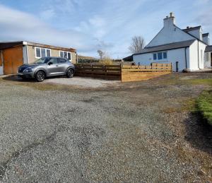 a car parked in a driveway in front of a house at Tigh Quiraing- Heather in Staffin +26 photos