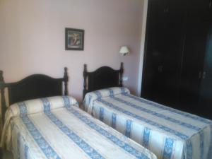 Łóżko lub łóżka w pokoju w obiekcie Hostal San Luis