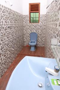 a bathroom with a bath tub and a toilet at Nimjaya holiday bunglow in Anuradhapura