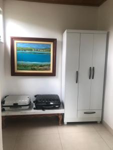 a room with a white cabinet and two suitcases on a bench at Casa Águas Claras in Palmeiras