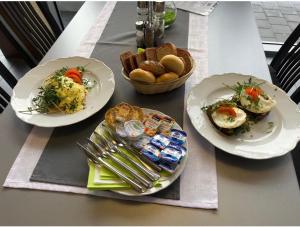a table with three plates of food and bread at GREEN HOTEL Ostrava in Jáma František