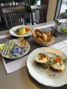 a table with plates of food and bread on it at GREEN HOTEL Ostrava in Jáma František