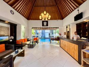 a large living room with a man standing at a bar at Mamo Hotel Uluwatu in Uluwatu