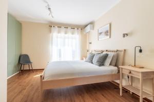 a bedroom with a bed and a desk and a window at Ericeira Beach Apartment in Ericeira