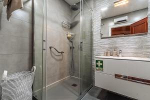 a bathroom with a glass shower and a sink at Ericeira Beach Apartment in Ericeira +34 photos