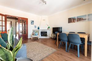 a living room with a table and chairs and a couch at Ericeira Beach Apartment in Ericeira