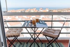a table with two drinks on a balcony at Ericeira Beach Apartment in Ericeira