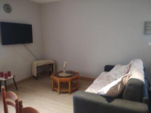 a living room with a couch and a tv at En passant par La Maraude in Vigneulles-lès-Hattonchâtel +6 photos