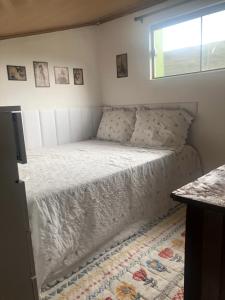 a bed in a small room with a window at Casa Águas Claras in Palmeiras