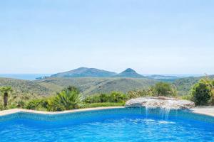 a swimming pool with mountains in the background at Ca na Lluny in Artá