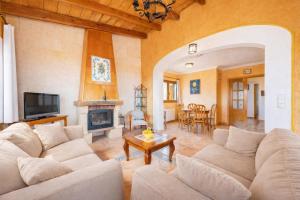 a living room with white couches and a fireplace at Ca na Lluny in Artá