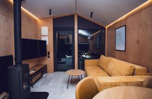 a living room with a couch and a fireplace at La Villa Chalet and Spa in Polyana