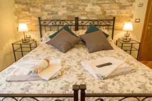 a bed with two towels and a remote control on it at B&B Centro Storico Viterbo in Viterbo