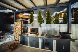 a outdoor kitchen with a fireplace on a patio at La Villa Chalet and Spa in Polyana