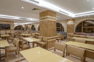 a restaurant with tables and chairs in a room at فندق رؤيا الاندلس النخبة - Roaya Alandalus Elite Hotel in Medina