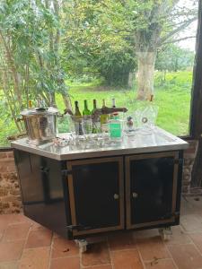 an island with wine bottles and glasses on it at Domaine de La Siaule in Saint-Germain-dʼAunay