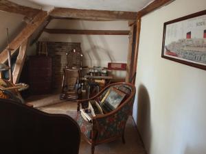 an attic room with a chair and a table at Domaine de La Siaule in Saint-Germain-dʼAunay +3 photos