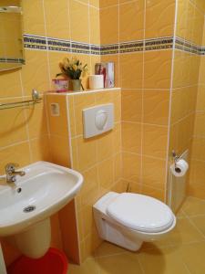 a yellow bathroom with a toilet and a sink at Apartament w Porcie Kołobrzeg latarnia morska plaża molo w zasięgu ręki in Kołobrzeg
