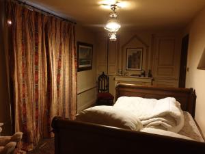 a bedroom with a bed with white sheets and a chandelier at Domaine de La Siaule in Saint-Germain-dʼAunay