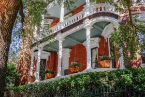 a white porch on a house with potted plants at Kehoe House, Historic Inns of Savannah Collection in Savannah
