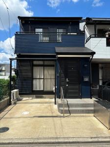 a blue house with a black door on a street at HOTTOSTAY OoGANE in Nagoya