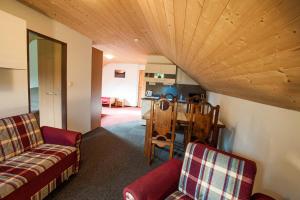 a living room with two couches and a table at Penzion a apartmány Skipark Hraběšice in Krásné