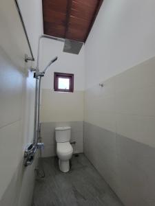 a bathroom with a toilet and a window at The Secret Place Hotel & Resort in Kandy +16 photos