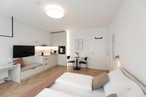 a white living room with a bed and a kitchen at Studio 4 in Bad Schallerbach