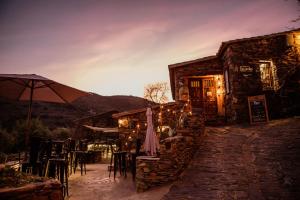 a restaurant with tables and chairs and an umbrella at La Cata Country House in Patones