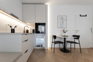 a kitchen with white cabinets and a table and chairs at Studio 4 in Bad Schallerbach