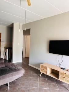 a living room with a couch and a tv on a wall at Honeypot Ridge 29 in Honeydew