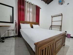 a bed in a room with a red curtain at The Secret Place Hotel & Resort in Kandy