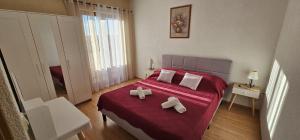 a bedroom with a bed with two towels on it at Apartments Sime in Sukošan +91 photos