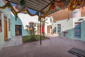 an alley with a tree in the middle of a building at Little prince guest house & homestay in Bikaner