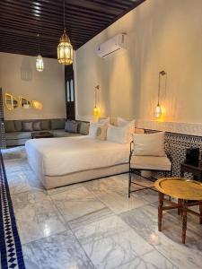 a bedroom with a large bed and a living room at Riad Citronnier & Spa in Fez +64 photos