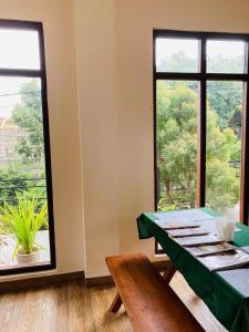 a dining room with a table and a large window at Emerald Mountain Resort in Ampitiya