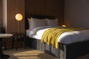 a bedroom with a bed with a yellow blanket on it at The 1898 Niseko in Kutchan