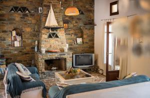 a living room with a couch and a tv at Villa Sophia in Andros