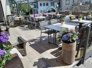 an outdoor patio with tables and chairs and flowers at B&B Kaiserstube in Flachau